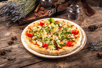 Italian fresh baked pizza with arugula and tomato