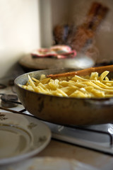 cooking fried potatoes in a pan on a home stove