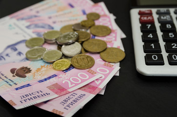 Close-up of new Ukrainian hryvnia, calculator and coins. 200 hryvnia. Financial concept.