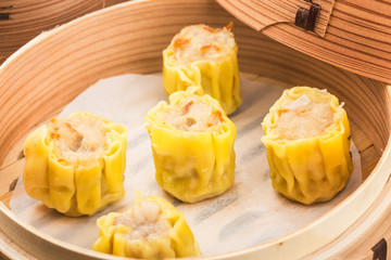 Chinese snacks: chinese yellow steamed dumpling. Chinese Traditional cuisine concept. Dumplings Dim Sum in bamboo steamer with text copy space.