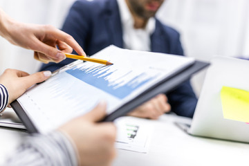 Close up of businessperson pointing at document in touchpad at meeting.