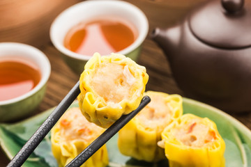 Chinese snacks: chinese yellow steamed dumpling. Chinese Traditional cuisine concept. Dumplings Dim Sum in bamboo steamer with text copy space.