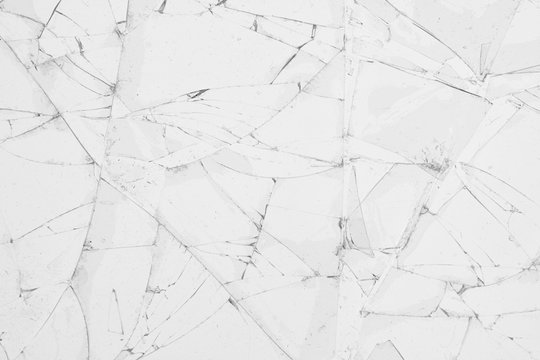 White cracked glass texture background. Texture broken glass window with cracks. Broken screen.