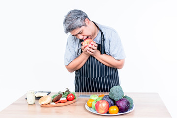 Portrait images of Asian middle-aged, Fat man are looking at hamburger With a craving to eat, while to choose fruits and vegetables to lose weight and health care