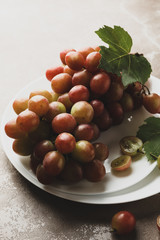 Plate of fresh grape on gray background