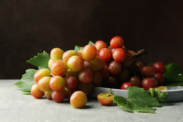 Tray of grape on gray table against brown background