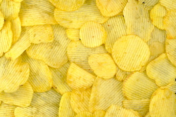 Potato chips yellow background. Unhealthy junk food.