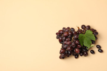Fresh ripe grape with leaves on beige background