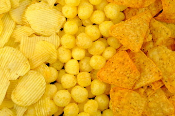 Junk food background. Mixed potato and corn chips.