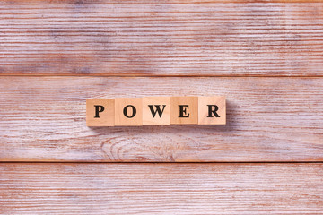Power Word Written In Wooden Cube. Concept of power or powerful in business