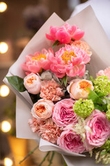 Flower shop. Beautiful bouquet of mixed flowers in man hands. The work of the florist at a flower shop. Delicate bright color. Fresh cut flower.