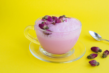 Closeup on rose moon milk in glass cup on the yellow surface