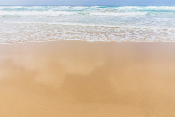 Fototapeta na wymiar View of the ocean waves, sandy beach and sky.