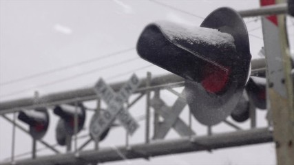 Snowstorm covers Train Railroad crossing Signal light with a dusting of snow - Powered by Adobe