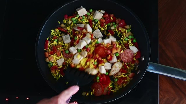 Elderly women hands. stirning food on frying pan, cooking chicken chorizo