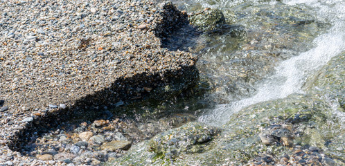 Clean water between the pebbles on the seashore