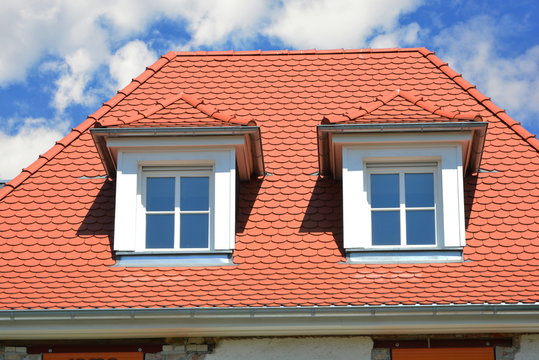 Renovierte Dachgauben mit Schiefer-Schindel-Verkleidung als Wetterschutz an einem denkmalgeschützten Wohngebäude