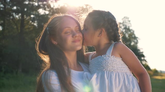 Happy family. Mother and daughter walk in the Park at sunset. Happy baby, kid hugs and kisses his mother in the forest. Happy people in the Park.