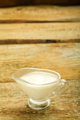 cream in a jug on a wooden table.