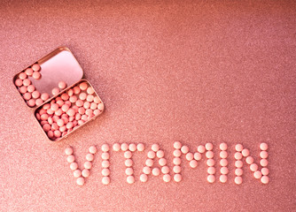 Headline vitamin. Medicine white pills and tablets and vintage tin cane on glitter pink background. Vitamins and minerals minimal concept, medicine and pharmaceutical flat lay. Copy space for text