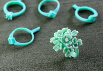 Put the white diamonds on the molds, flower buds for making rings, green molds from the wax for the gem industry.