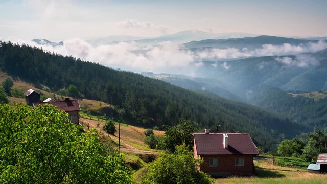 Time lapse with playful, fast-moving morning mists over the tree-covered mountain slopes and the villages nestled in them, Rhodope mountains in Bulgaria
