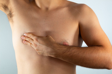 close up of a man's chest looking for signs of male breast cancer - obrazy, fototapety, plakaty