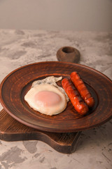 Fried sausages on a plate with scrambled eggs close-up and copy space. Boiled sausages and fried eggs for breakfast in a plate.