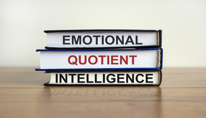 Fototapeta premium Books with text 'emotional quotient intelligence' on beautiful wooden table. White background. Business concept.