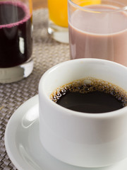 Café da manhã de hotel com café, suco de uva, achocolatado e suco de laranja	