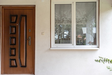 front door next to the window, detail of the exterior of a small house