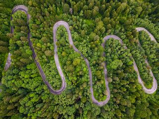 Winding road through the forest, from high mountain pass, aerial view