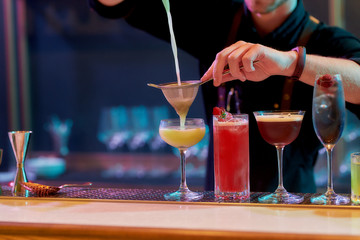 Great Taste. Close up of hands of male bartender pouring, mixing ingredients while making...