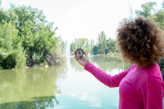 woman using her compass by the river - Powered by Adobe