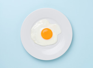 fried egg on turquoise blue background
