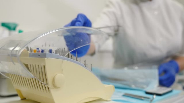 Healthcare concept. dentist choosing and taking bor for teeth drilling in modern dental office, close-up view. sterile appropriate drill for dental instrument. Hand taking out sterile dental tools. 4