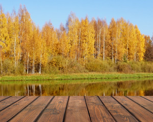 Naklejka na ściany i meble Empty wooden table on a autumn blurred background.