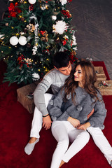 Top view of couple sitting on carpet near fireplace and Christma