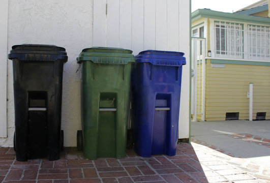 Trash bins for separate disposal of garbage, outside the house. Trash cans of different colors for sorting garbage.