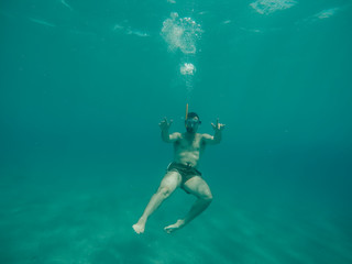 Young boy diving under the sea.