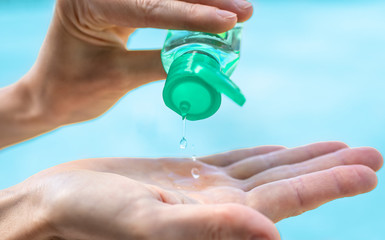 Person disinfecting hands with alcohol. Body care and hygiene concept. 