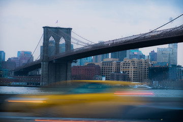 Fototapeta na wymiar A taxi rushes by a bridge in New York 