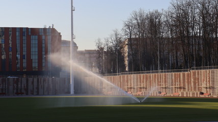 green football pitch and watering the lawn process