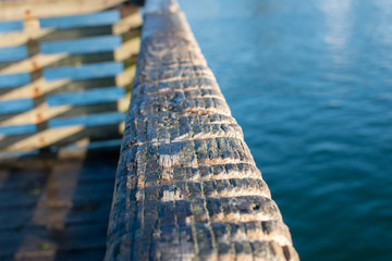 Wear grooves in the wood railing, made by people tying their crab pots to the rail on a pier in Newport Oregon.
