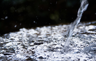 Rozprysk wody spadającej na tafle w jednej z fontann w parku miejskim