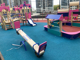 children's pink playground in the center of the residential complex. there are swings, slides and...