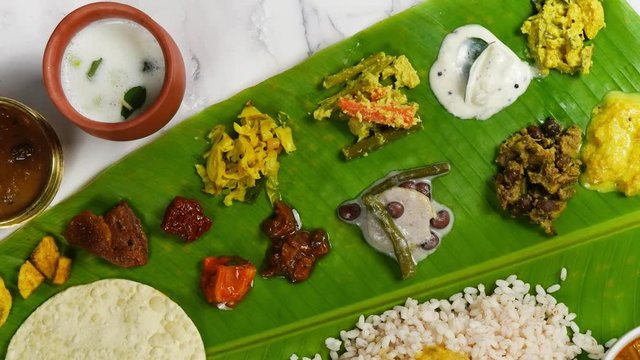 Traditional Kerala Onam feast / Sadya served on a banana leaf  
