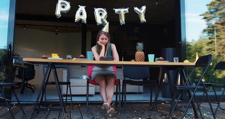 Lame birthday party on quarantine. Sad upset Caucasian young beautiful woman sits alone at home...