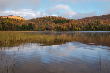 Fototapeta na wymiar Fall scene on Connery Pond with mountains and water in the Adirondacks, New York