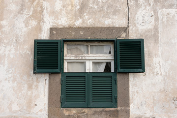 Fototapeta na wymiar Old broken window with green shutters. 